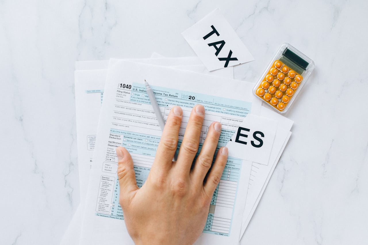 Mastering the First Impression: Your intriguing post title goes here Close-up of a hand on tax form 1040 with a calculator on a desk.