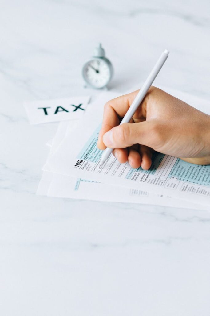 The Art of Drawing Readers In: Your attractive post title goes here Hand completing tax forms with a pen, symbolizing financial deadline and time urgency.